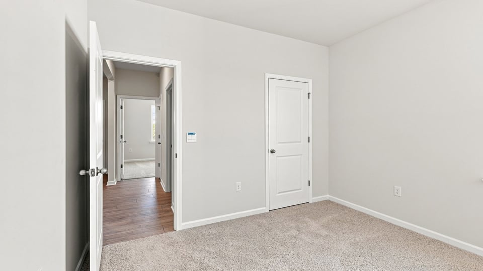 Bedroom with carpet and window.