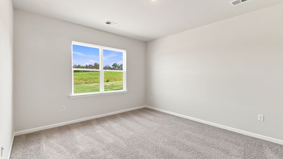 Bedroom with carpet and windows.