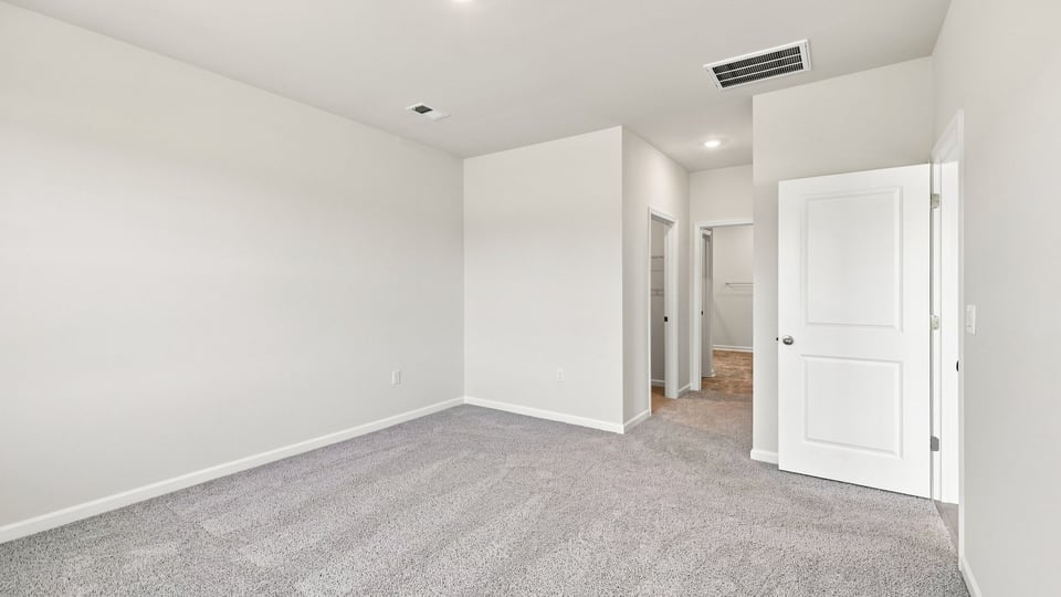 Bedroom with carpet and windows.