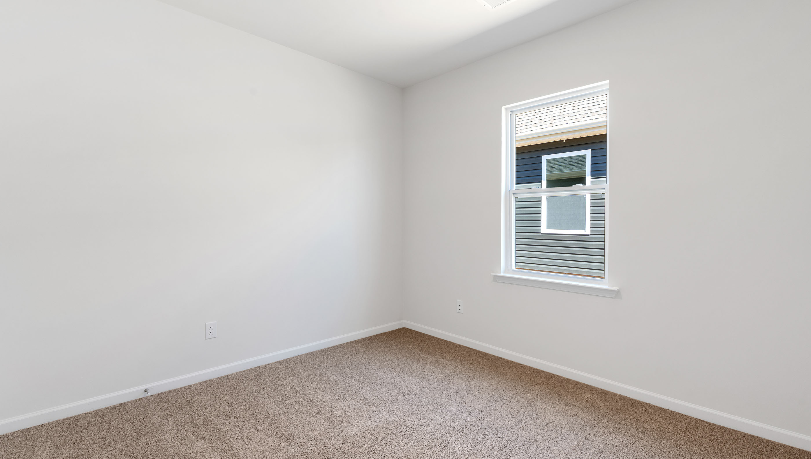 Bedroom with carpet and windows.