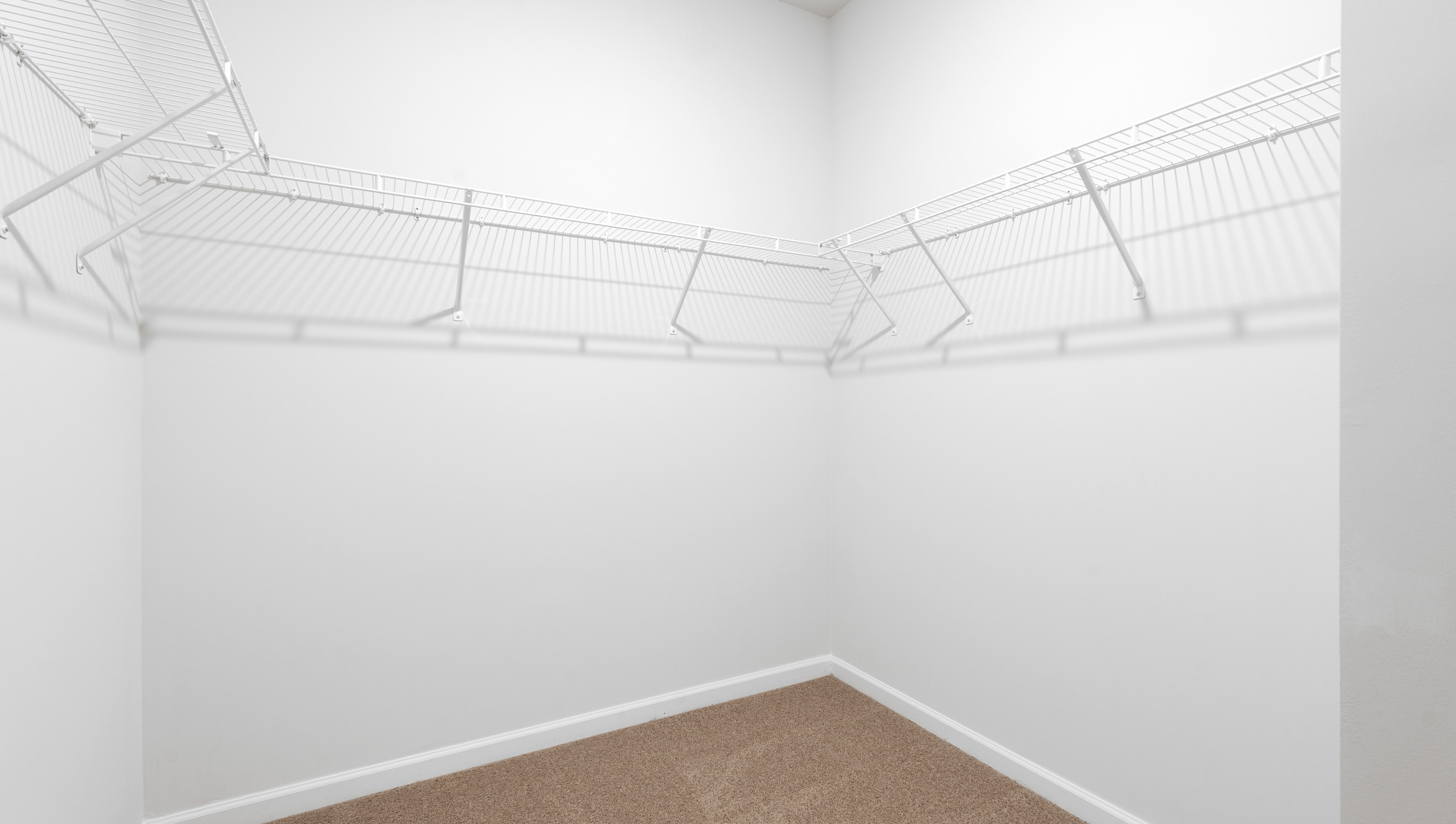 Walk in closet with hanging shelves.