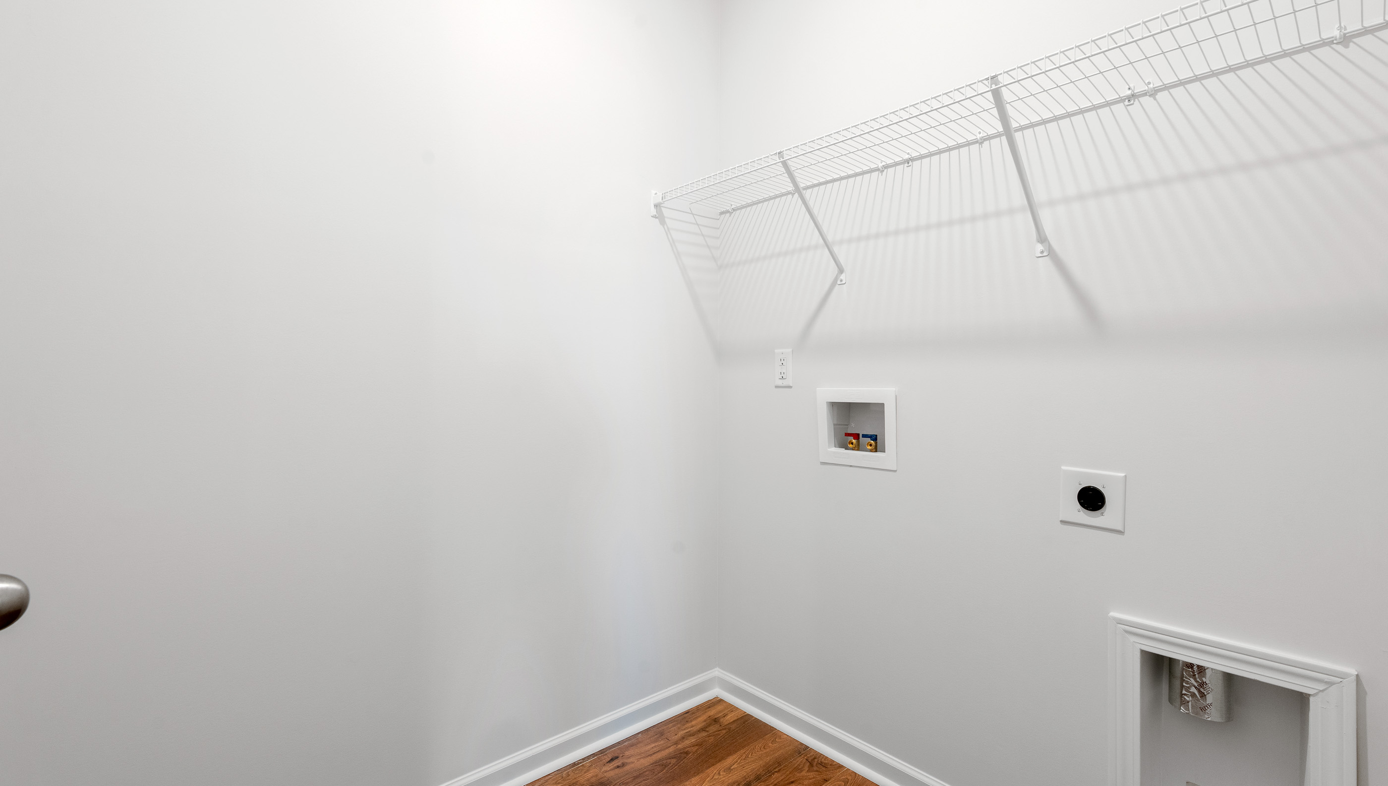 Walk in laundry with hanging shelves.