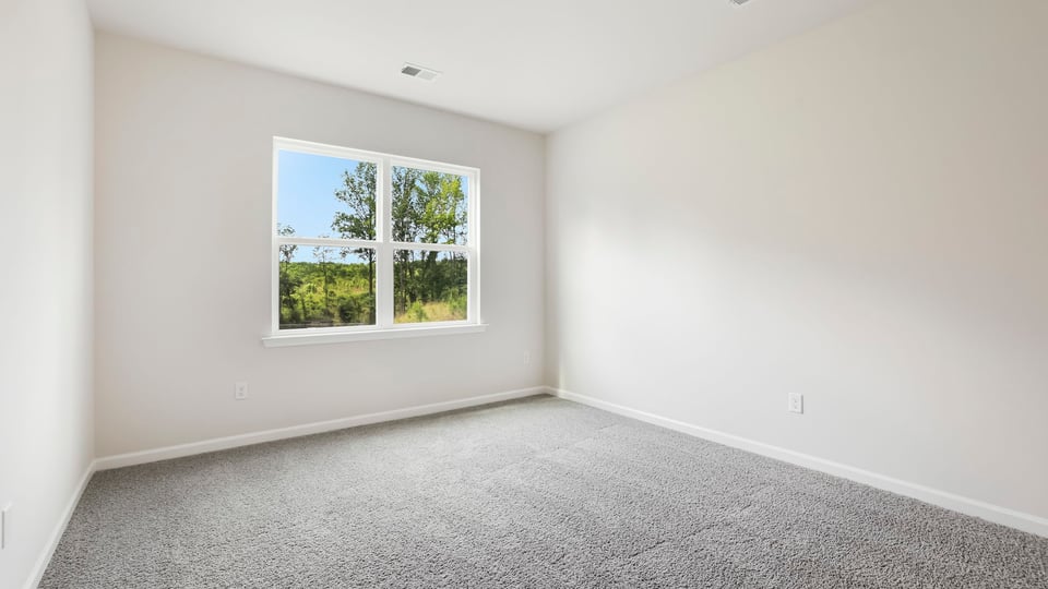 Bedroom with carpet and windows.