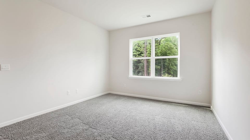 Bedroom with carpet and windows.