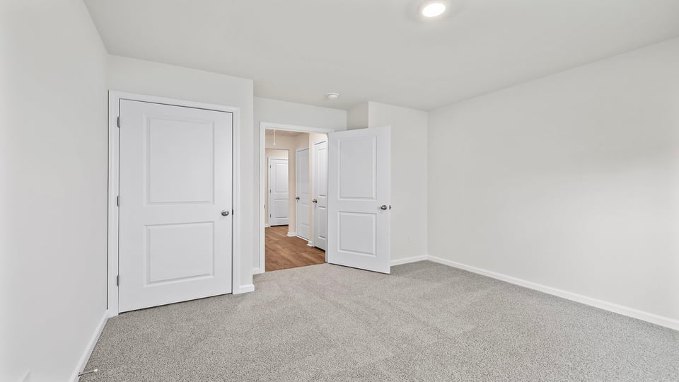Bedroom with carpet and window.