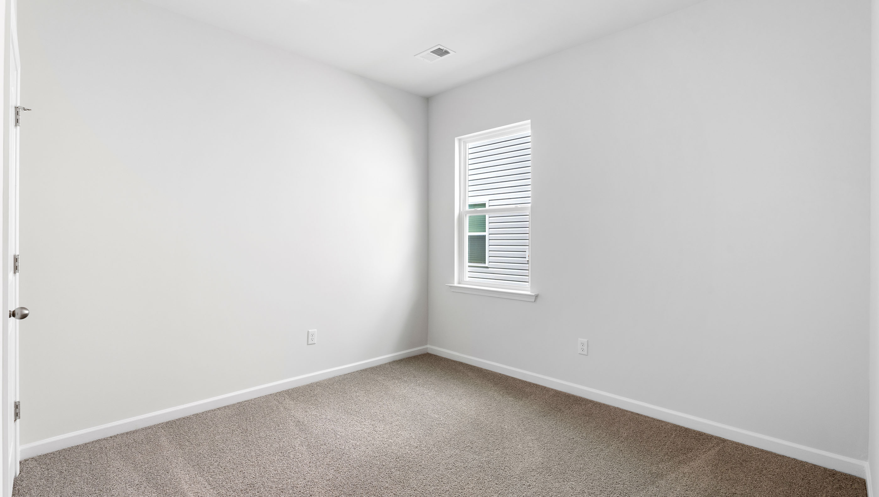 Bedroom with carpet and windows.