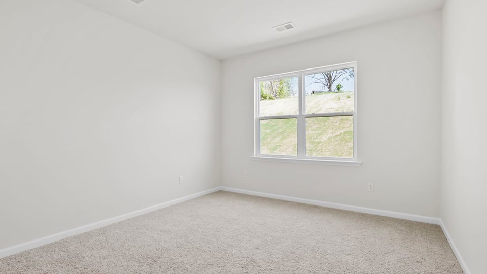 Bedroom with carpet and window.