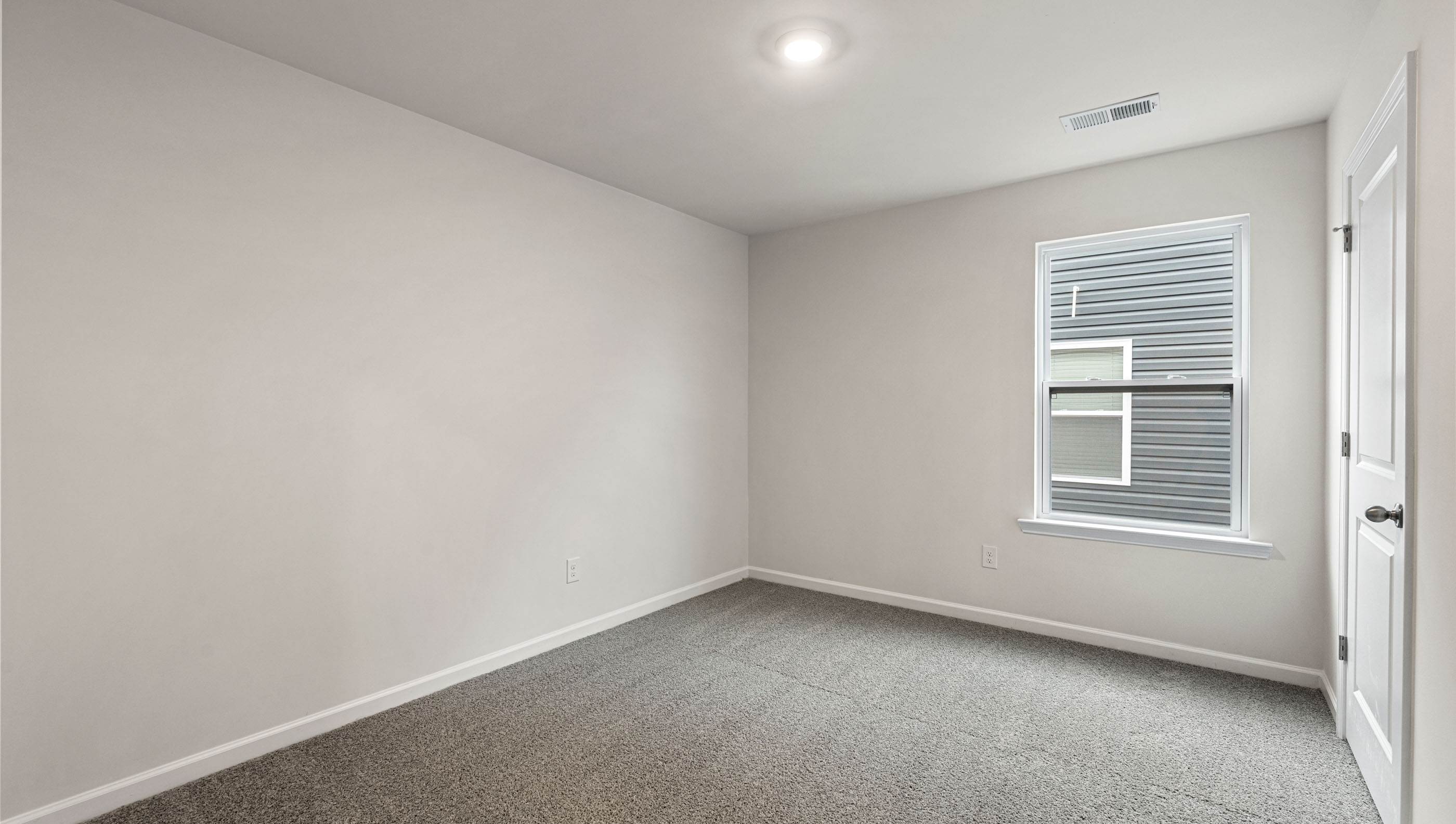 Bedroom with carpet and window.