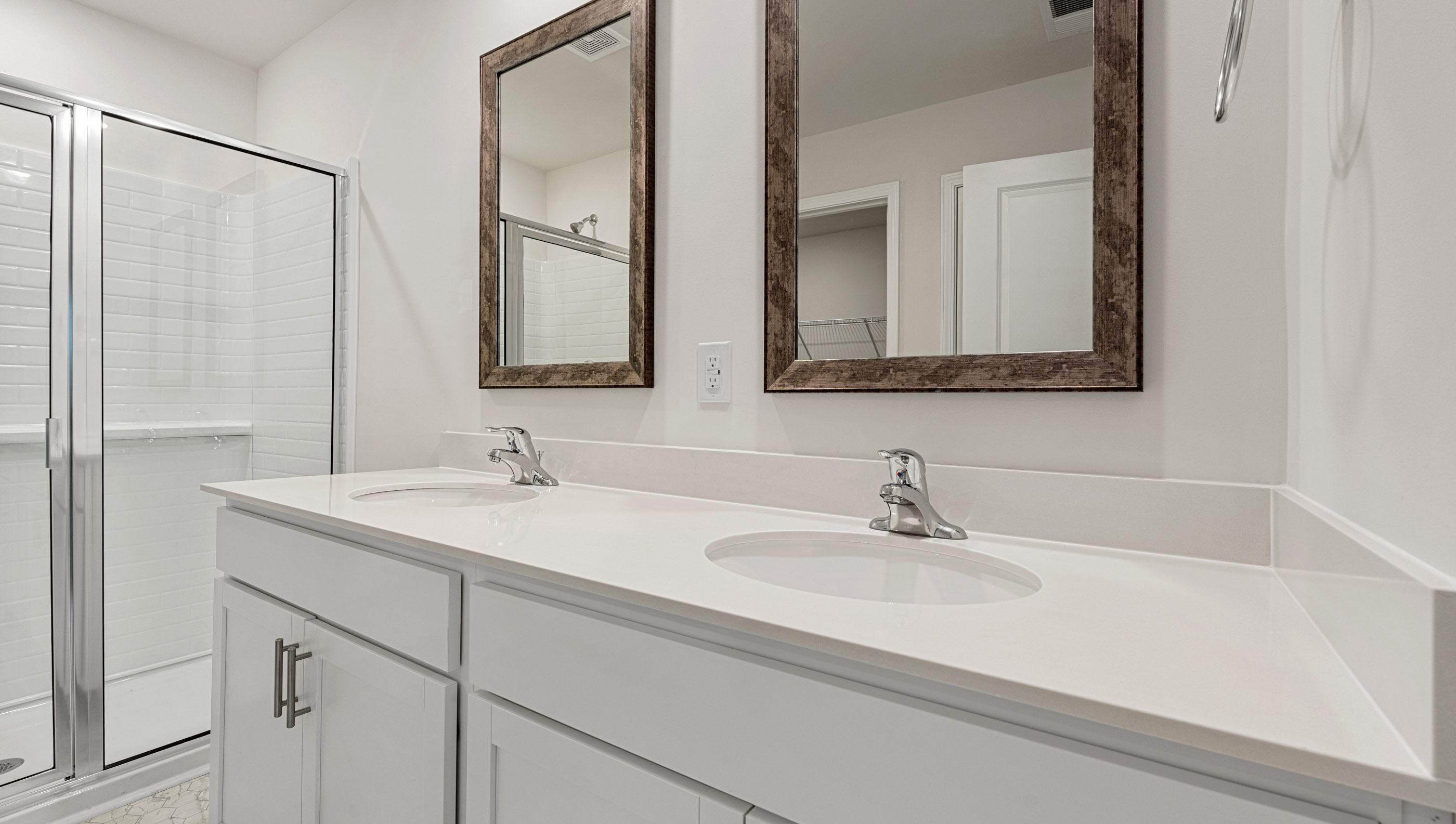 Bathroom with double vanity sink and walk in shower.