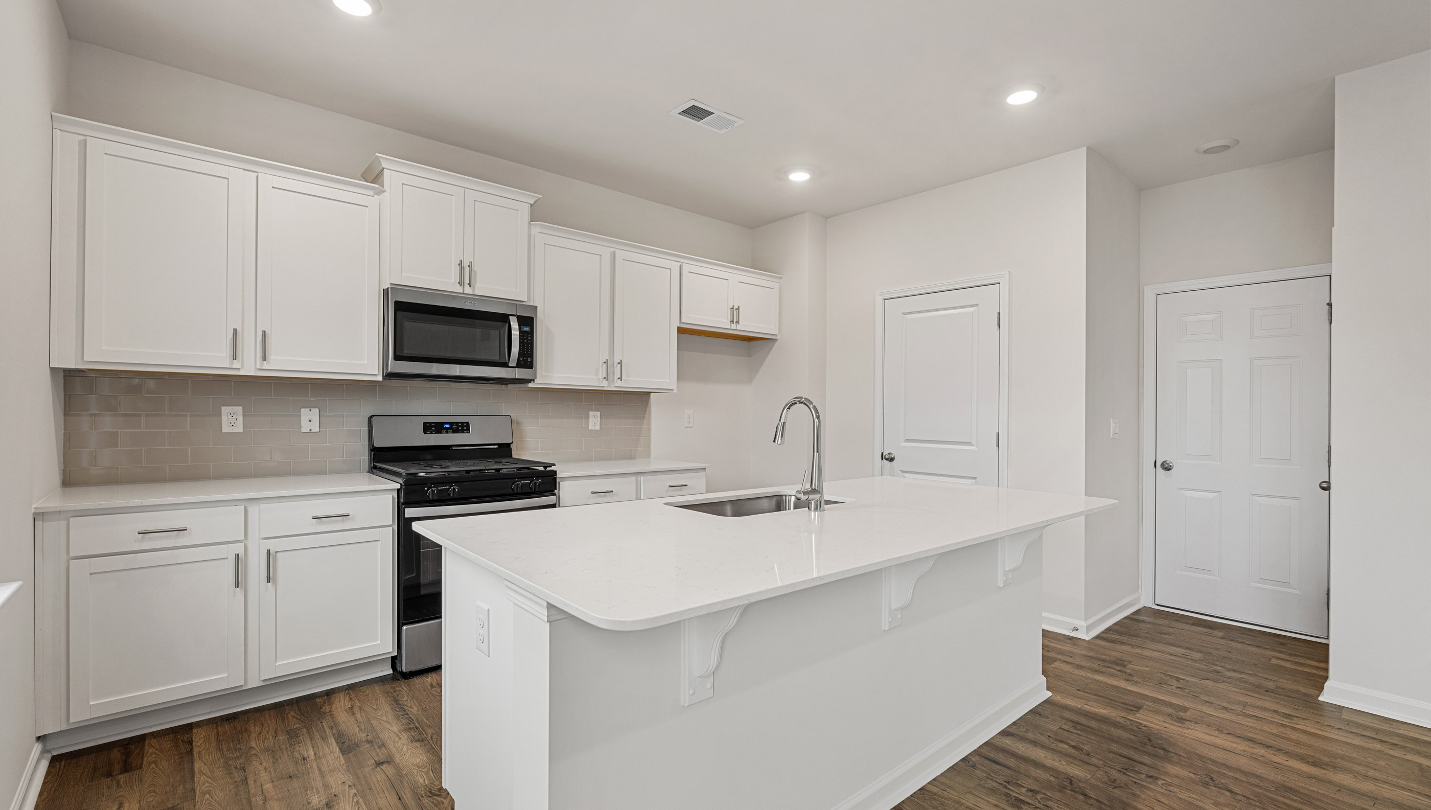 Kitchen and island with quartz countertops.