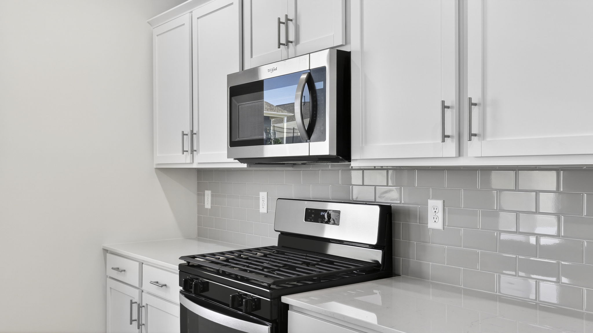 Kitchen and island with quartz counter tops and stainless steel appliances.