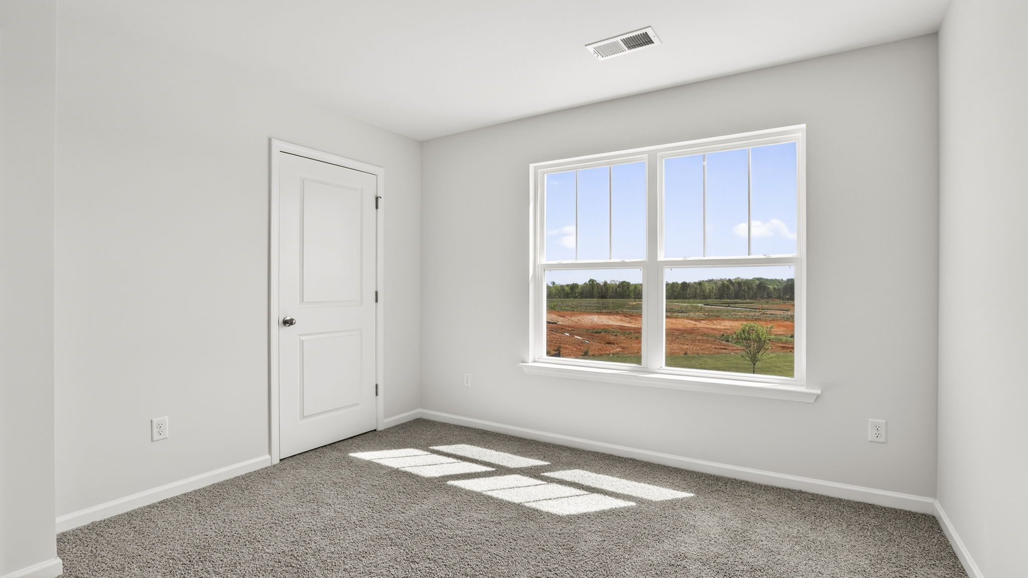 Bedroom with carpet and windows.