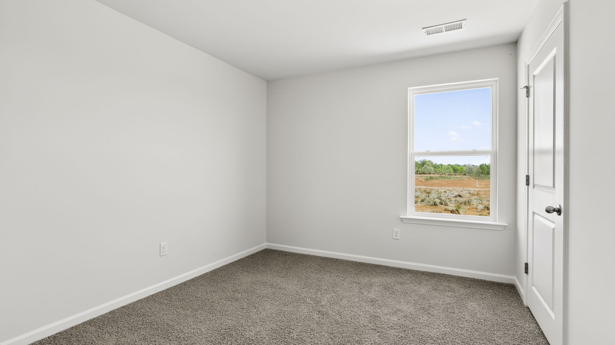 Bedroom with carpet and windows.