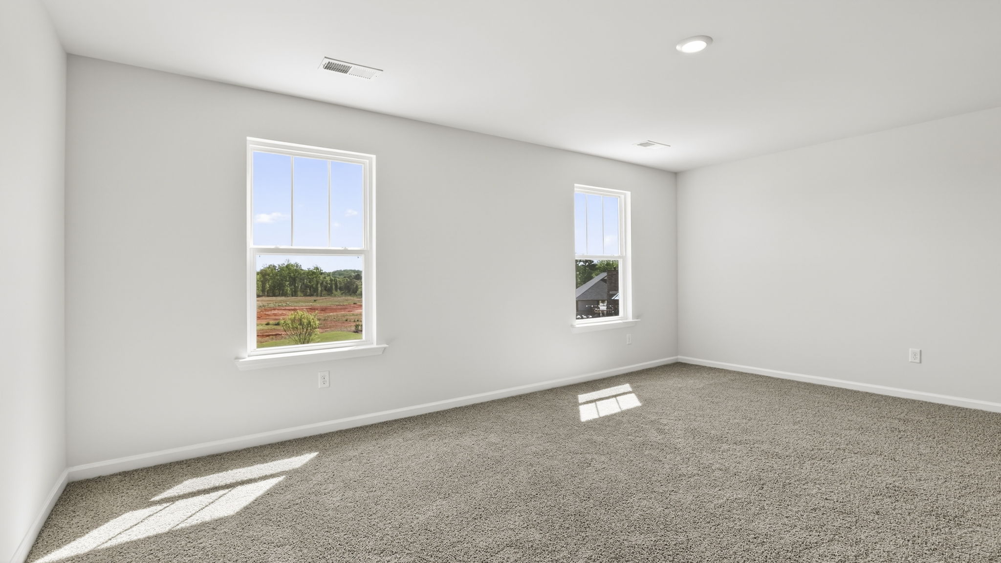 Bedroom with carpet and windows.