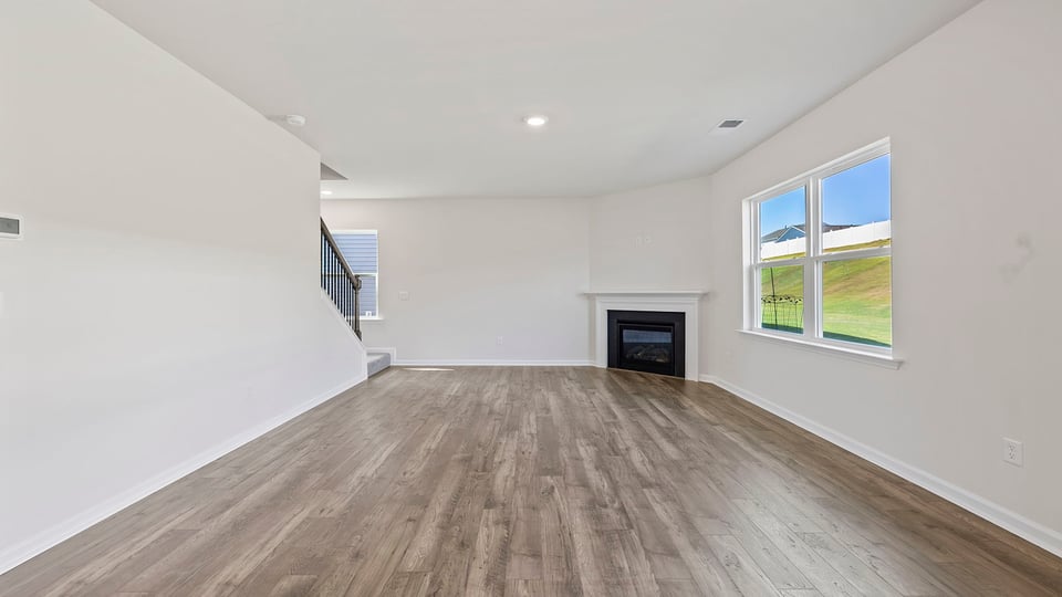 Living room with large window and fireplace.