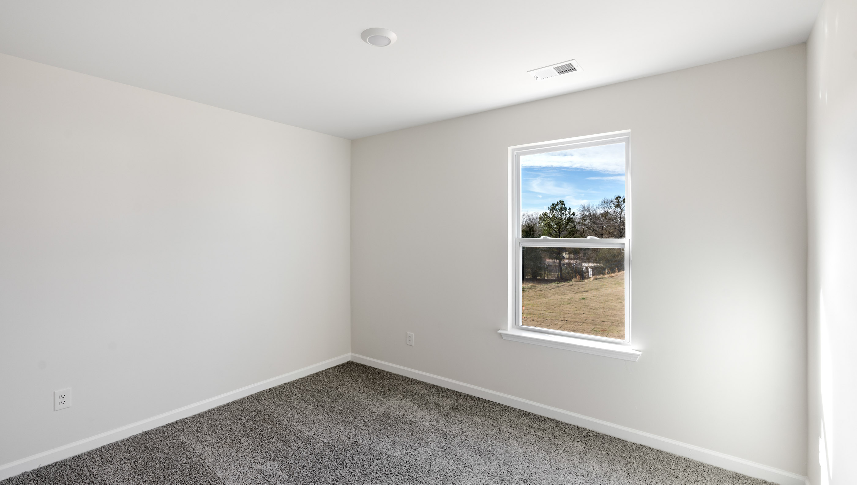 Bedroom with carpet and window.