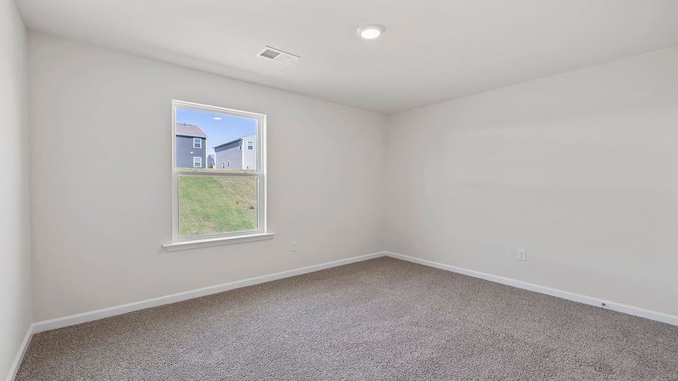 Bedroom with carpet and windows.