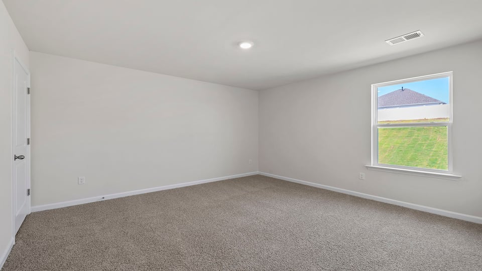 Bedroom with carpet and windows.