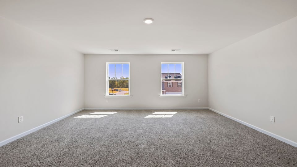Bedroom with carpet and windows.