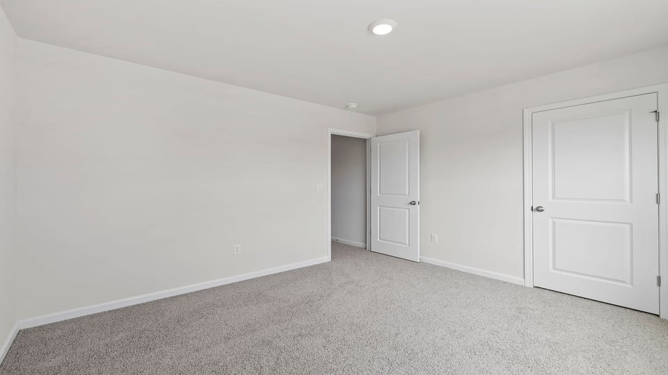 Bedroom with carpet and windows.