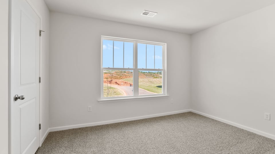 Bedroom with carpet and window.