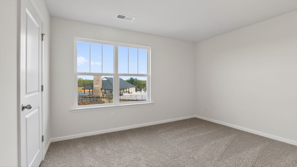 Bedroom with carpet and window.