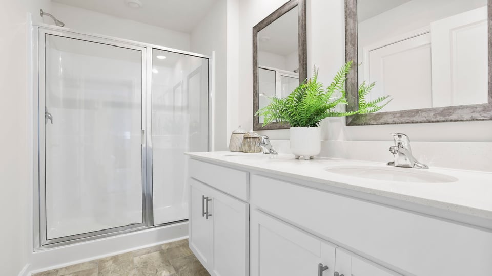 Bathroom with double vanity sink and walk in shower.