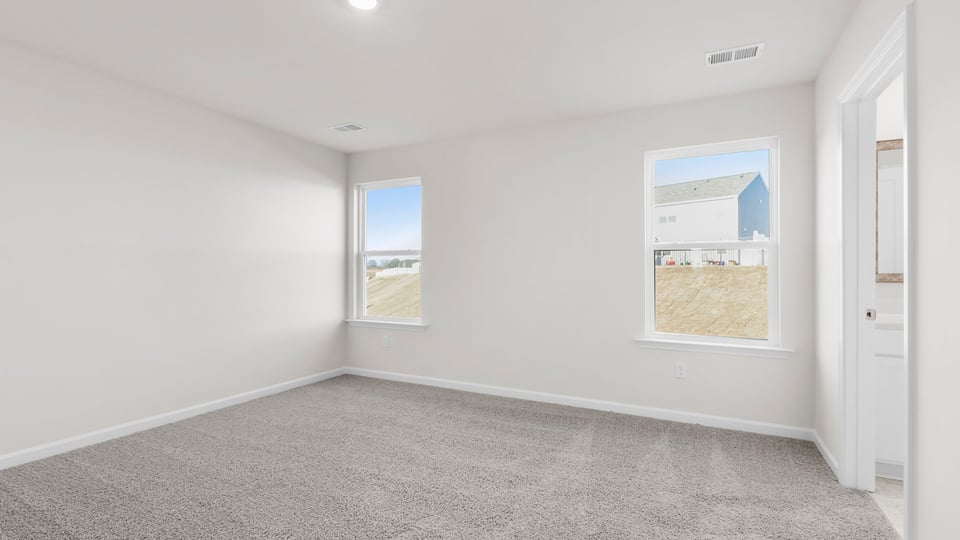 Bedroom with large window and carpet.