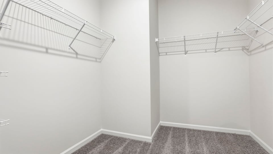 Walk in closet with carpet and shelves.