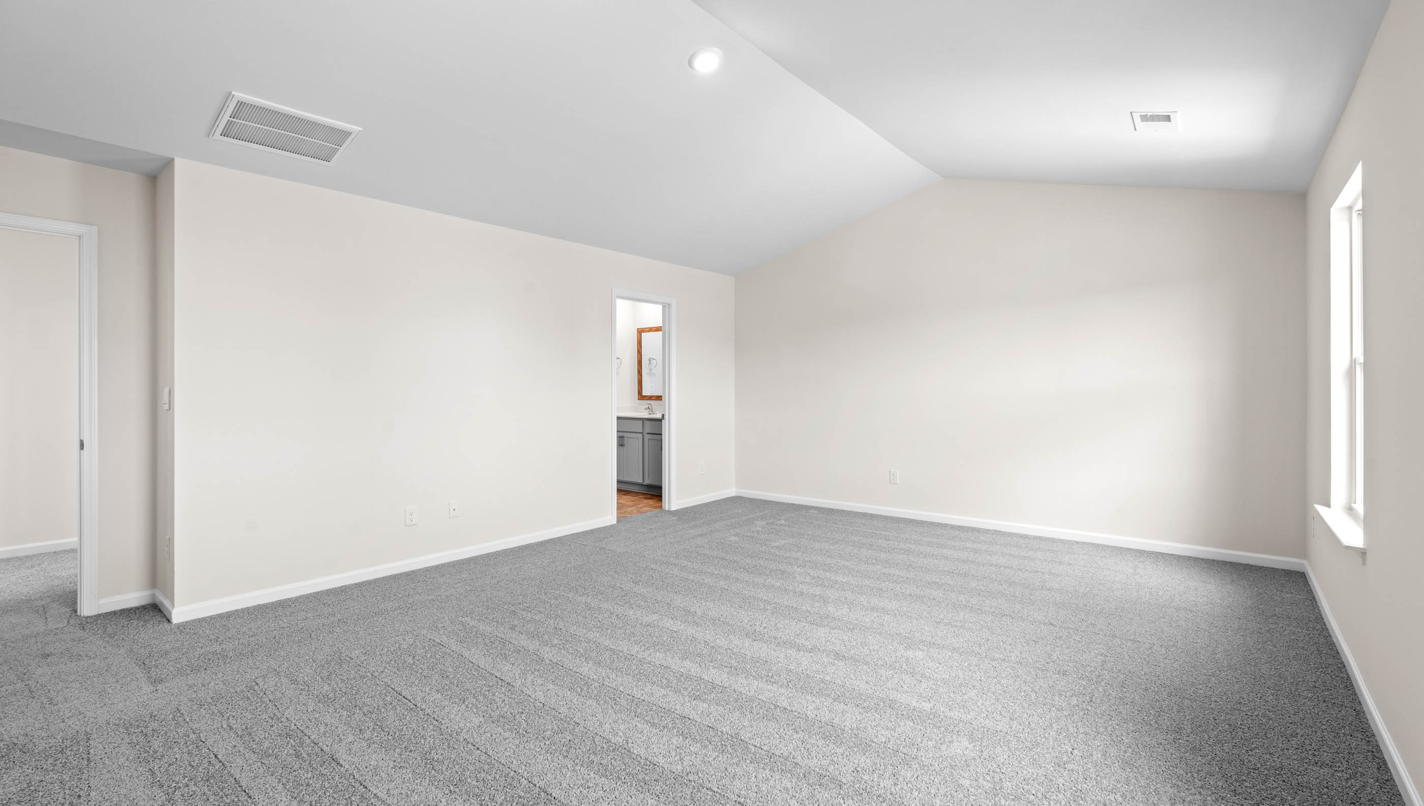 Primary bedroom with window and carpet.