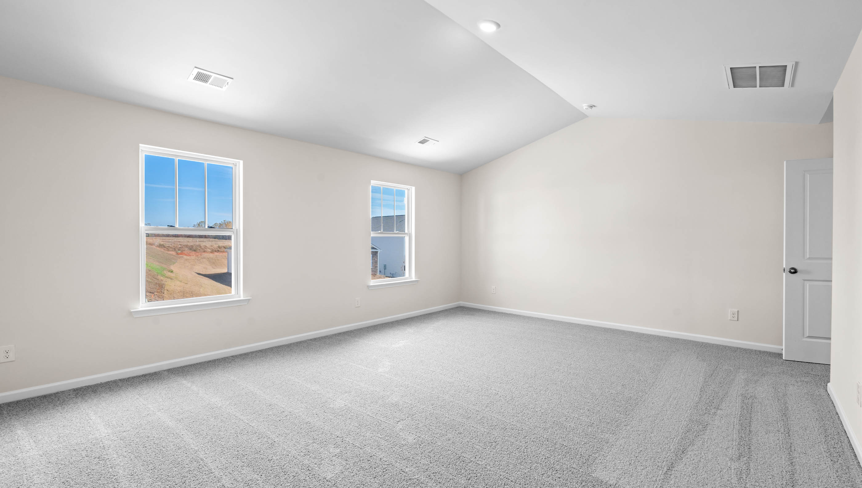 Primary bedroom with window and carpet.