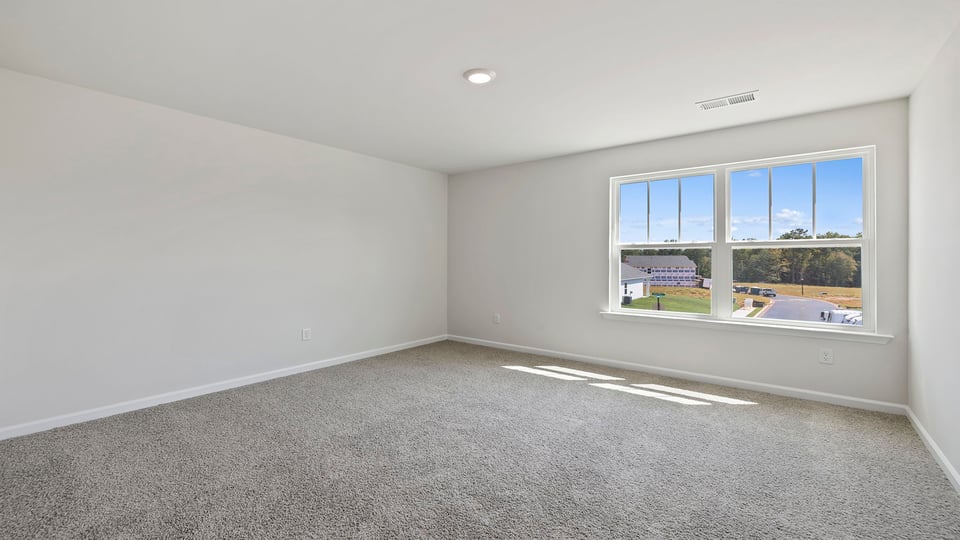 Bedroom with carpet and windows.
