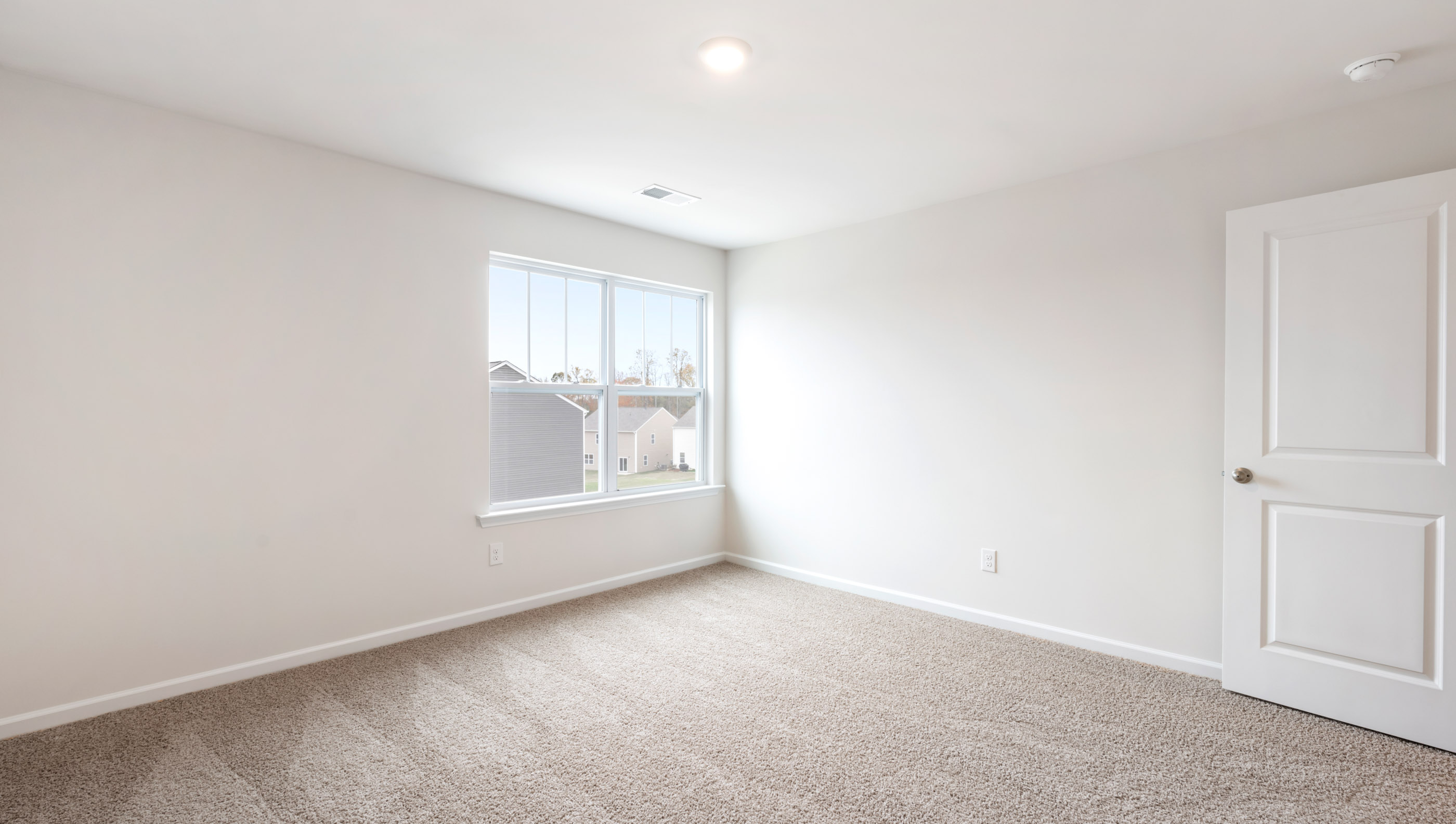 Bedroom with carpet and windows.