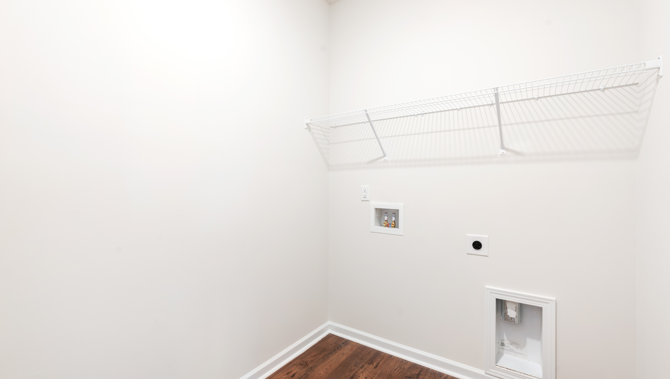 Walk in laundry with hanging shelves.
