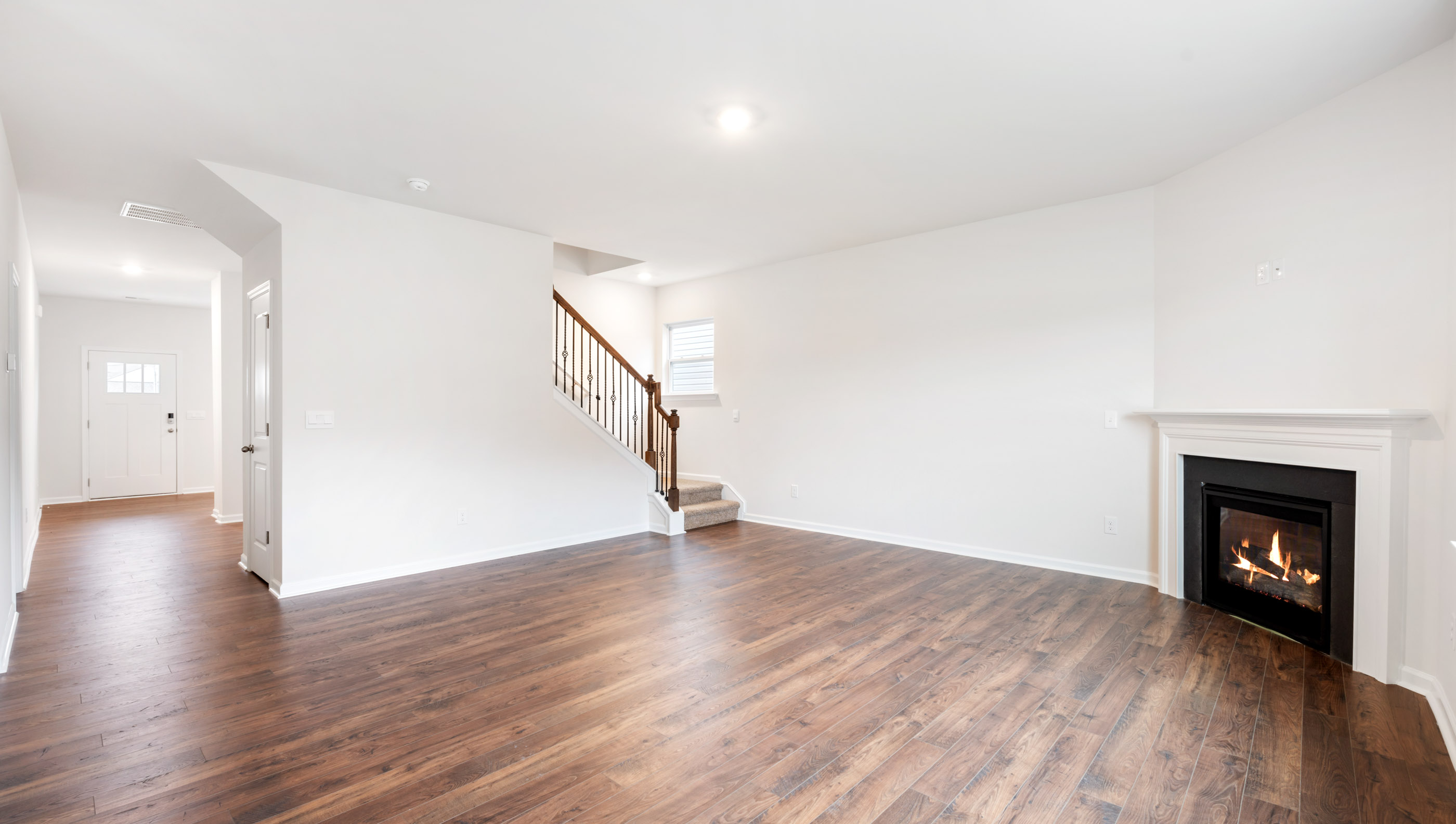 Family room with fireplace and view of staircase to second level.
