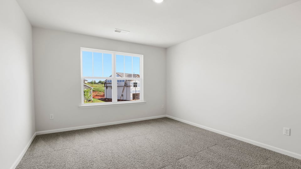 Bedroom with carpet and window.