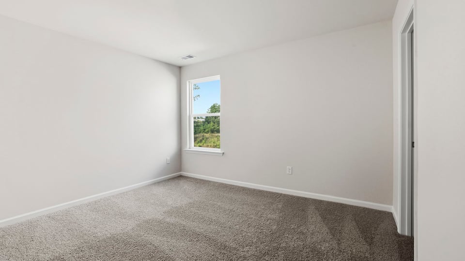 Bedroom with carpet and window.