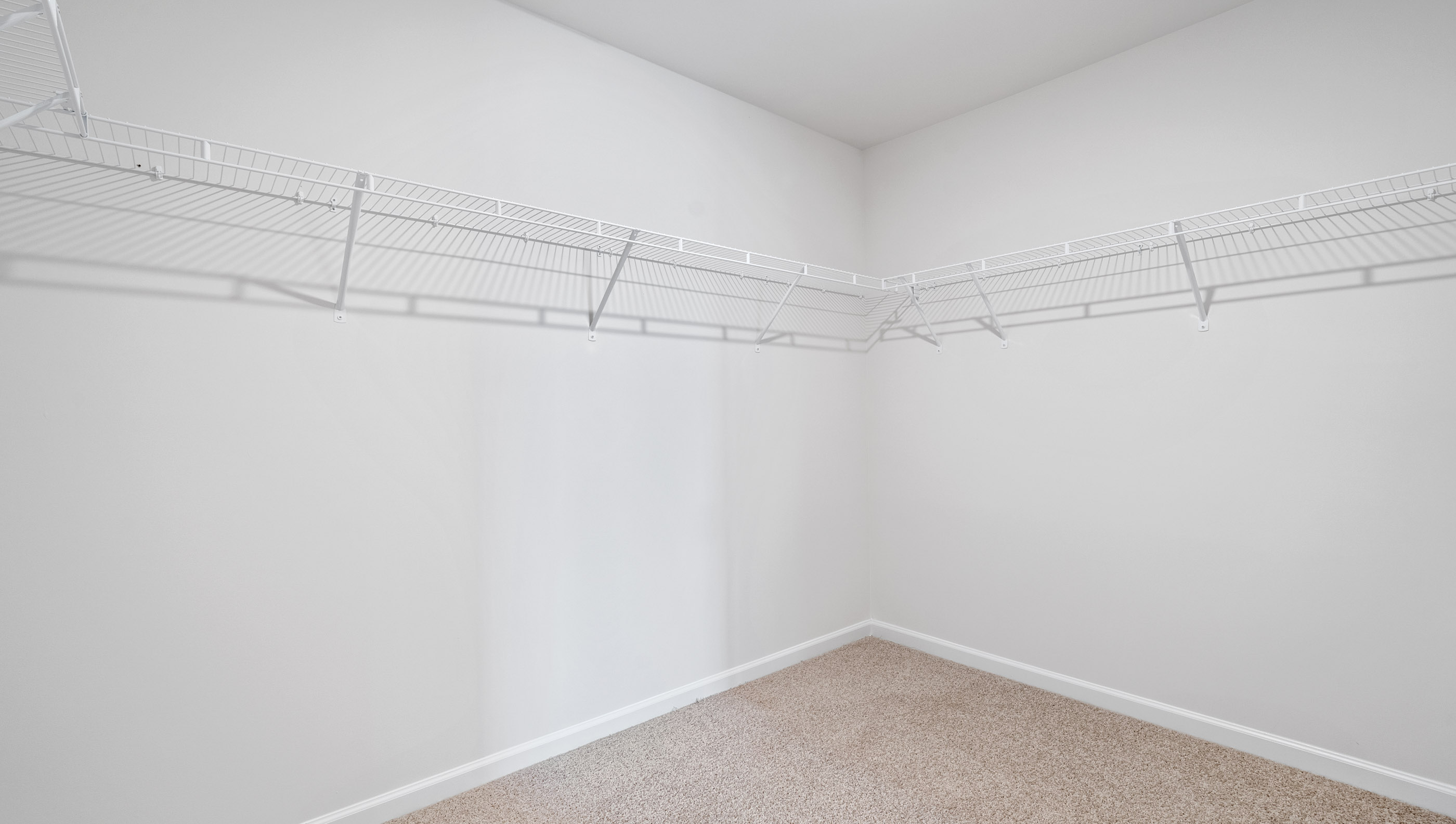 Walk in closet with hanging shelves.