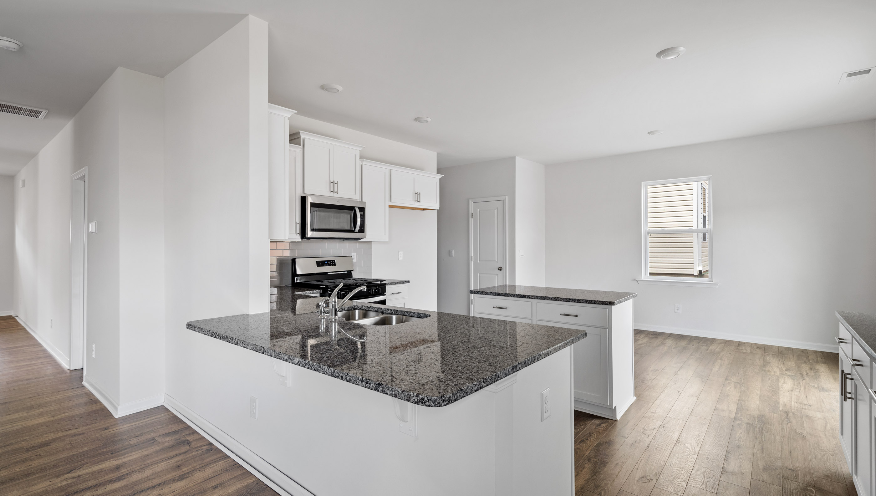 Kitchen with granite and stainless steel appliances.