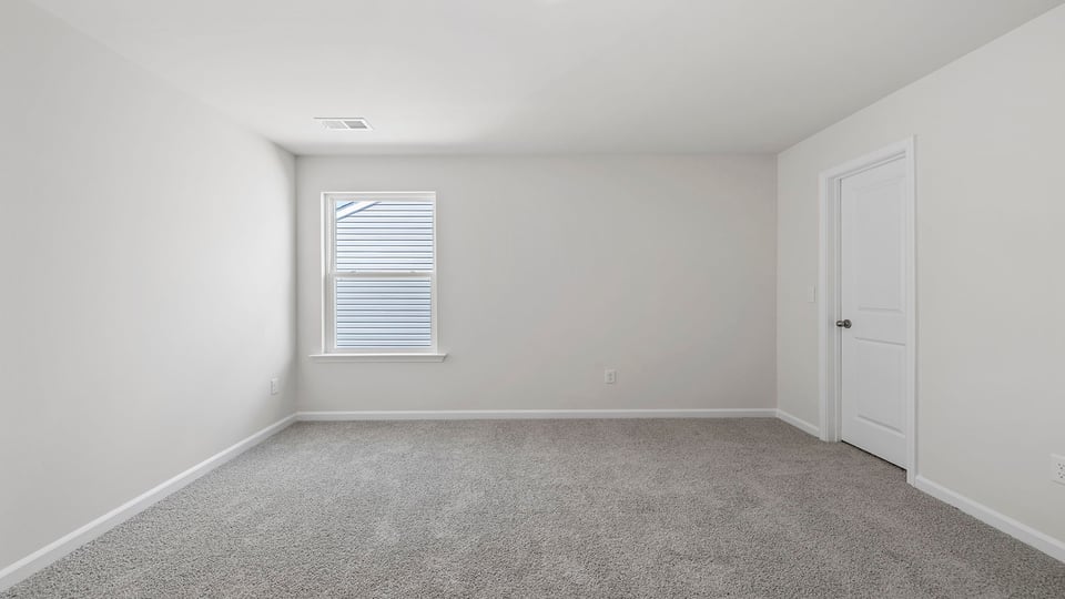 Bedroom with carpet and windows.