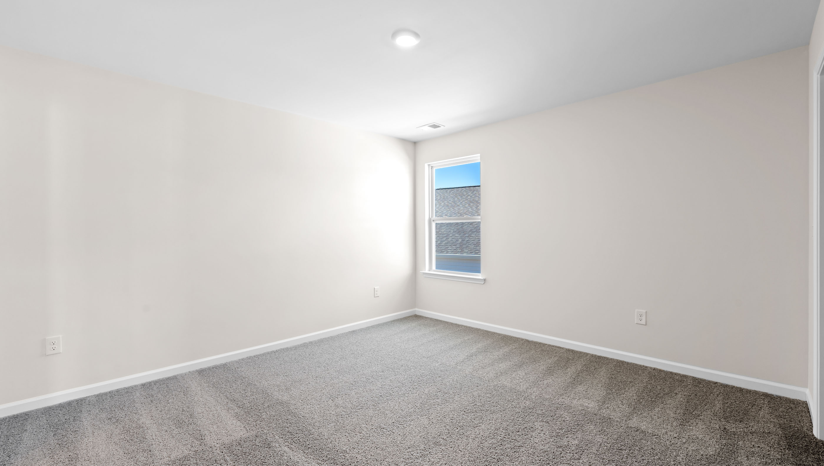 Bedroom with carpet and windows.