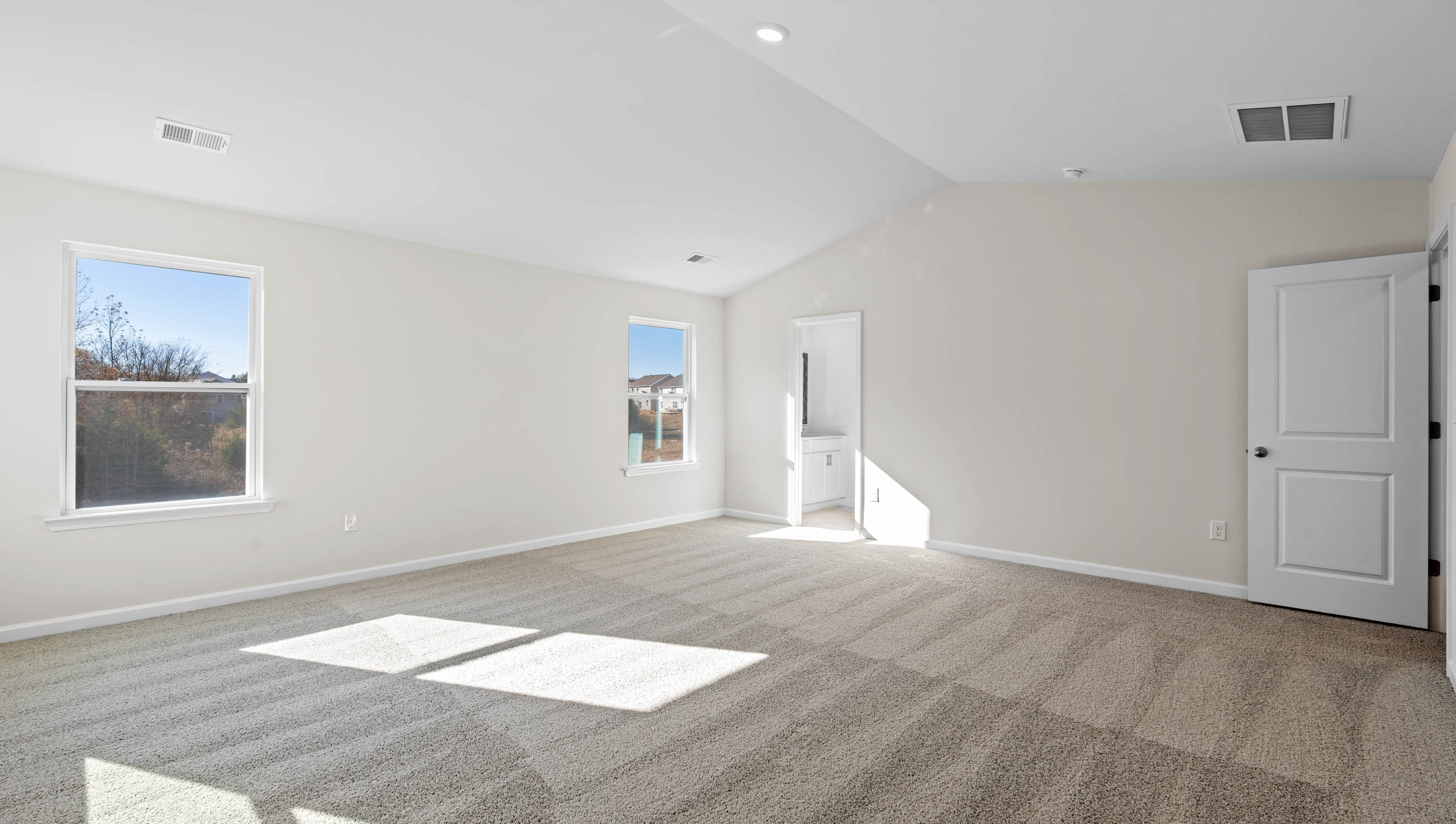 Bedroom with carpet and windows.