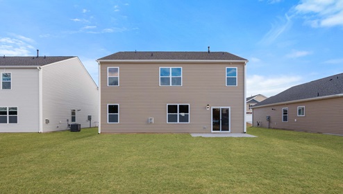 Back exterior of home with large backyard.