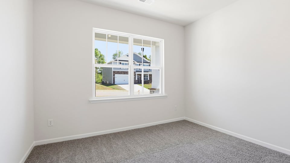 Bedroom with carpet and window.