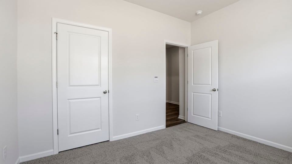 Bedroom with carpet and window.