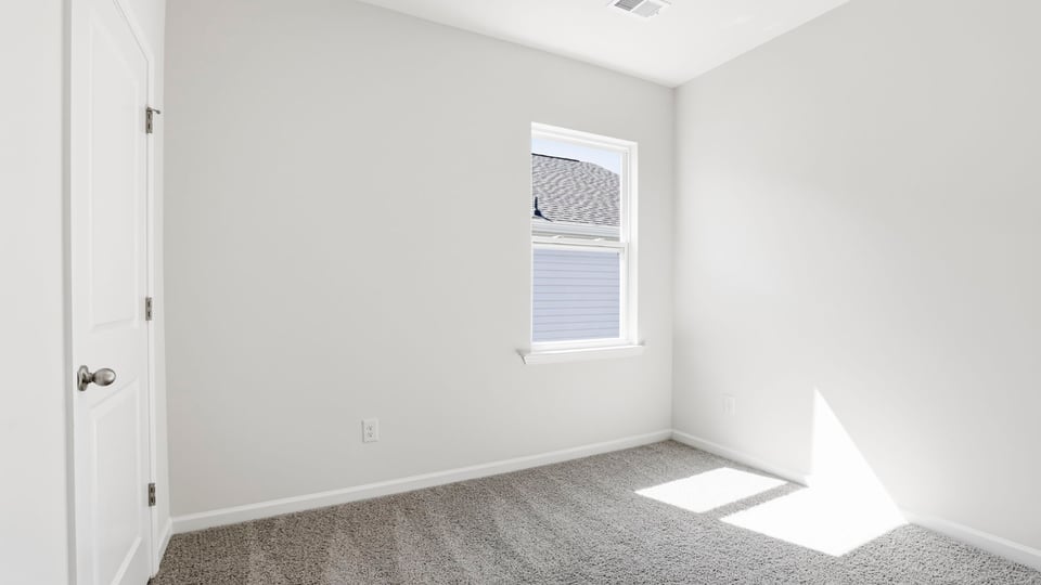 Bedroom with carpet and window.