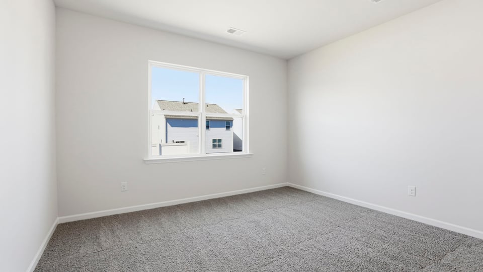 Bedroom with carpet and window.