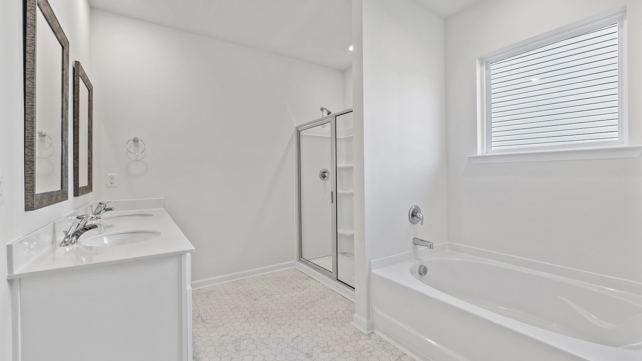Bathroom with double sink vanity, walk in shower and tub.
