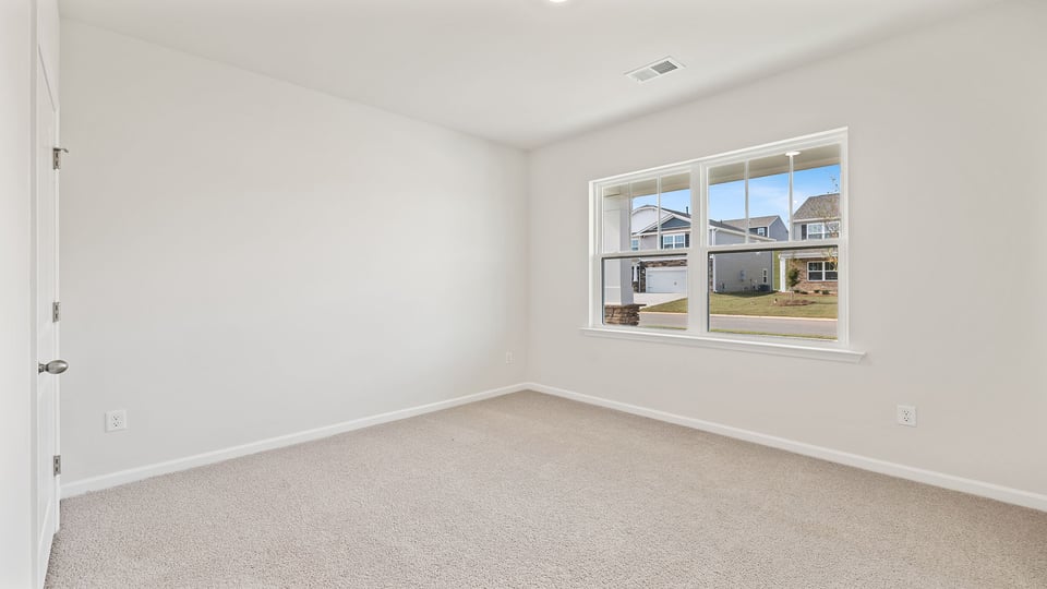 Bedroom with carpet and window.