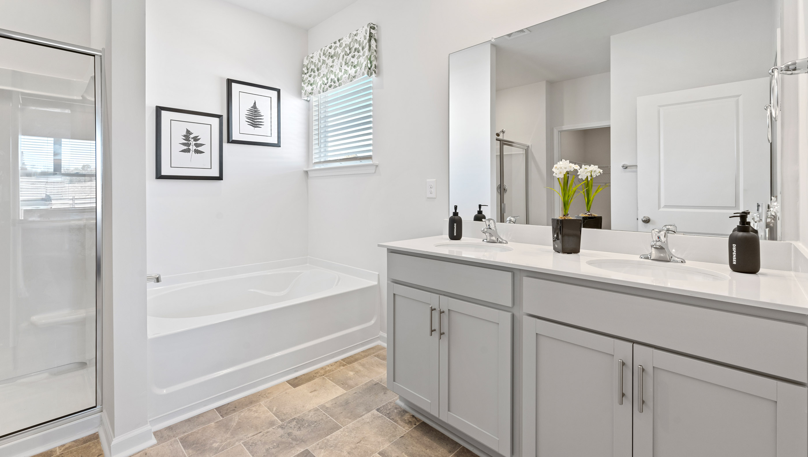 Bathroom with double vanity sink and shower.